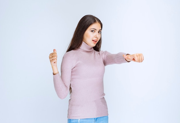 Foto gratuita mujer con camisa morada mostrando algo arriba.