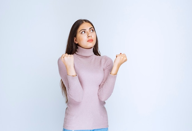 mujer con camisa morada mostrando sus poderosos puños.