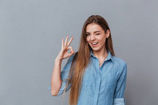 Mujer en camisa mostrando signo ok