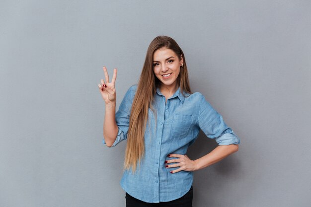 Mujer en camisa mostrando el signo de paz