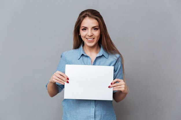 Mujer en camisa mostrando tablero en blanco