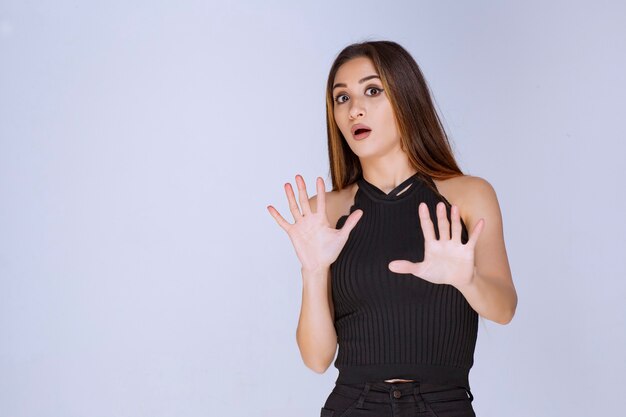 Mujer en camisa negra dando parada a algo.