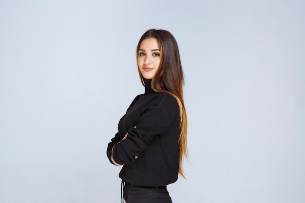 mujer en camisa negra dando poses neutrales y coquetas.