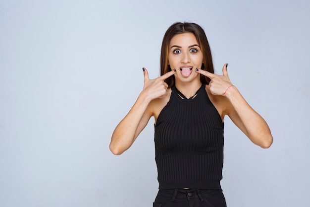 Mujer con camisa negra sacando la lengua.