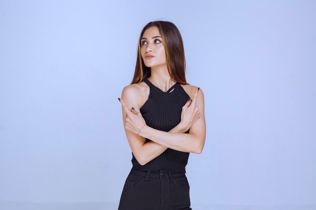 Mujer con camisa negra se ve desagradable y sonriente.