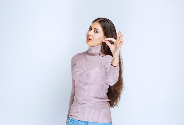 mujer en camisa púrpura que muestra el signo de la mano de disfrute.