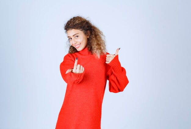 mujer con camisa roja notando a alguien adelante y enviando energía positiva.