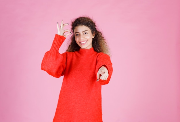 mujer con camisa roja notando a alguien adelante y enviando energía positiva.