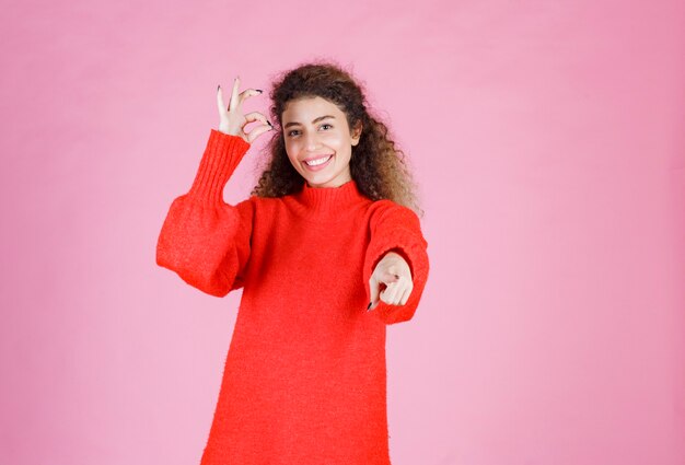 mujer con camisa roja notando a alguien adelante y enviando energía positiva.