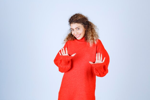 mujer con una camisa roja parando algo.