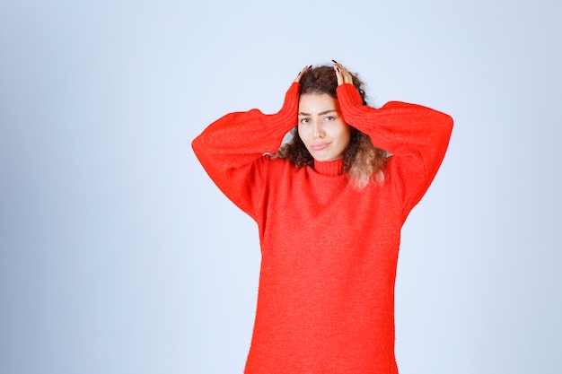 mujer con una camisa roja parece aterrorizada y asustada.