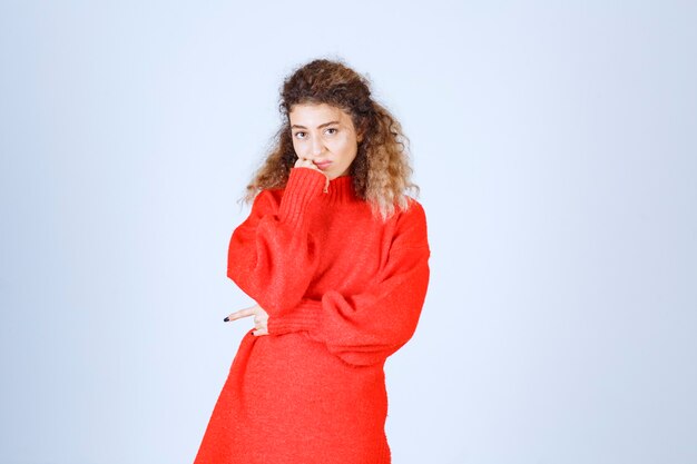 mujer con camisa roja parece pesimista o triste.