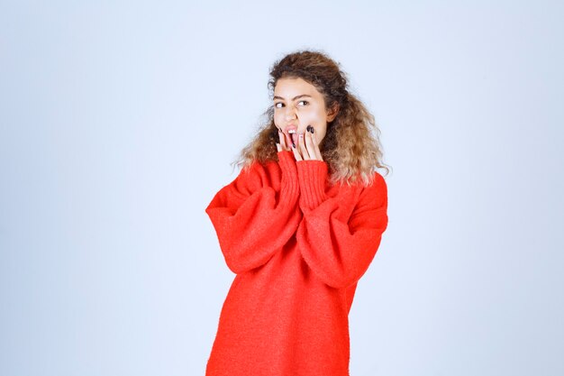 mujer con camisa roja parece pesimista o triste.