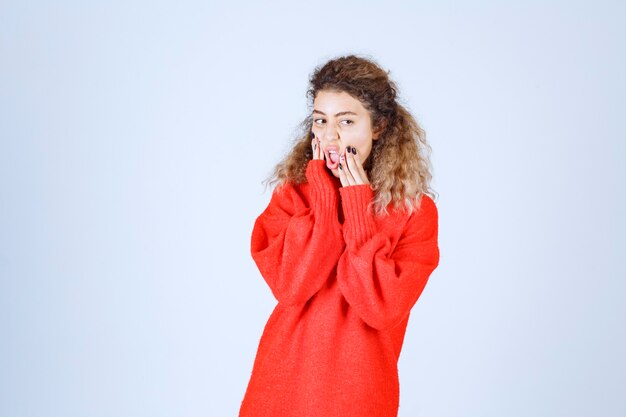 mujer con camisa roja parece pesimista o triste.