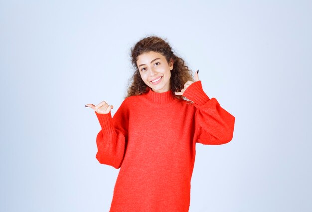 mujer en camisa roja que muestra el distintivo de llamada.