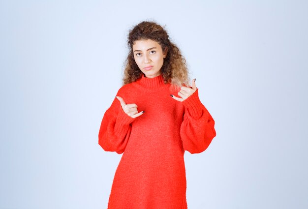 mujer en camisa roja que muestra el distintivo de llamada.