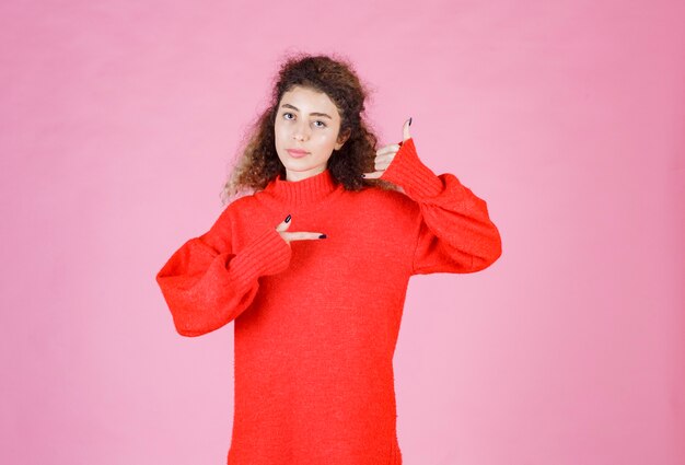 mujer en camisa roja que muestra el distintivo de llamada.