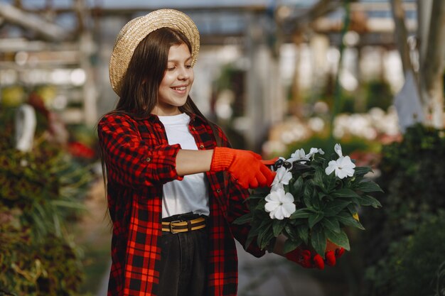 Mujer con camisa roja. Trabajador con macetas. Hija con plantas