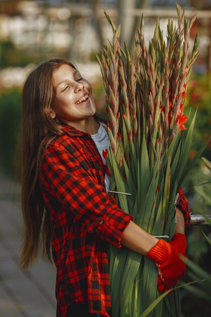 Mujer con camisa roja. Trabajador con macetas. Hija con plantas