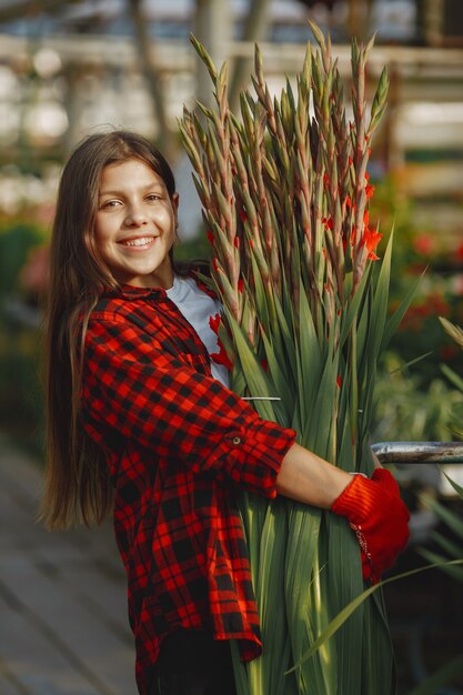 Mujer con camisa roja. Trabajador con macetas. Hija con plantas