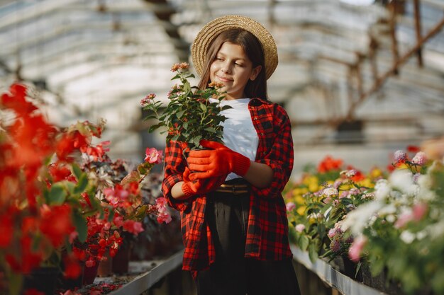 Mujer con camisa roja. Trabajador con macetas. Hija con plantas