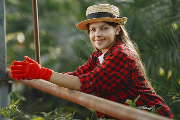 Foto gratuita mujer con camisa roja. trabajador con macetas. hija con plantas