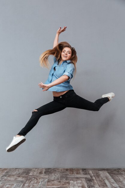 Mujer en camisa saltando en studio