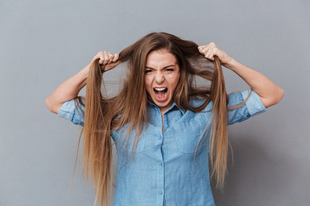 Mujer en camisa sosteniendo su cabello