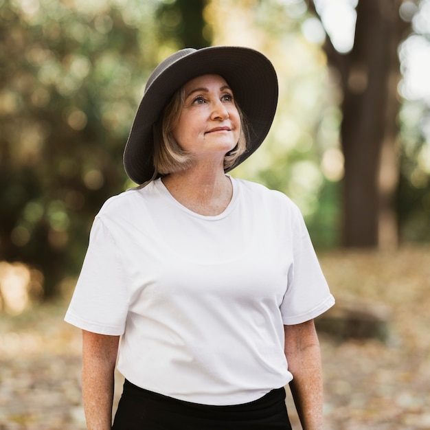 Mujer en camiseta blanca apreciando la belleza de la naturaleza