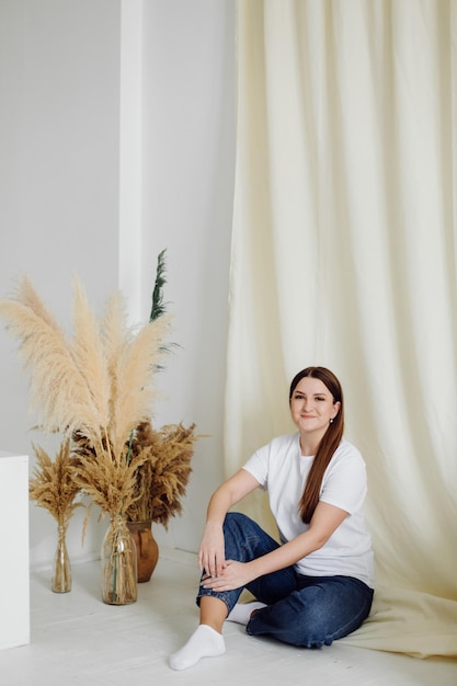 Mujer con camiseta blanca en blanco de pie en el fondo