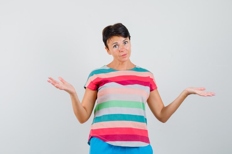 Foto gratuito mujer en camiseta a rayas, pantalones haciendo gesto de escalas y mirando confundido