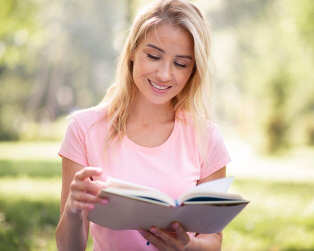 Mujer en camiseta rosa leyendo vista frontal