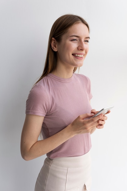 Mujer en camiseta rosa de pie y mirando a otro lado