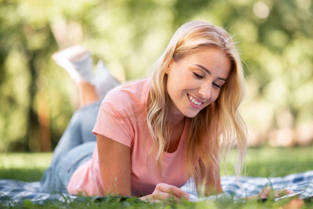 Mujer en camiseta rosa sentada en el parque