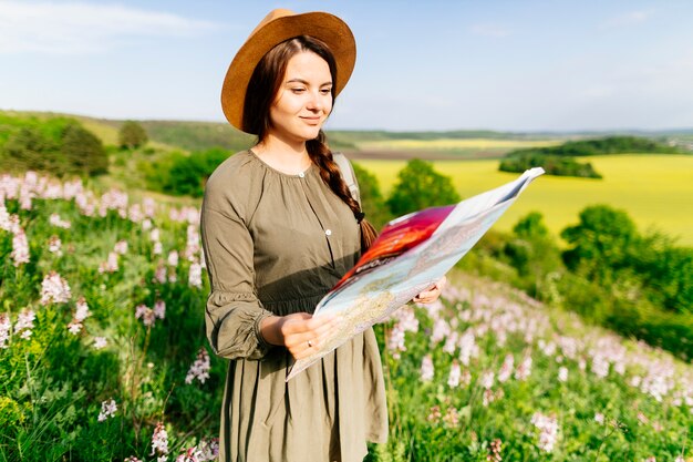 Mujer en campo mirando a mapa