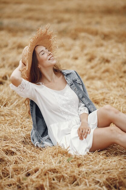 Mujer en un campo de verano. Dama con un vestido blanco.