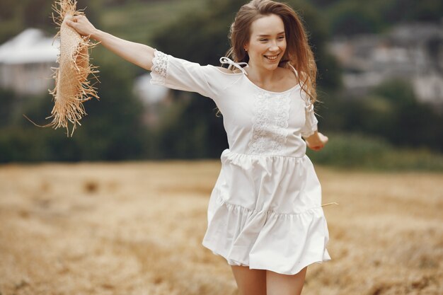 Mujer en un campo de verano. Dama con un vestido blanco.