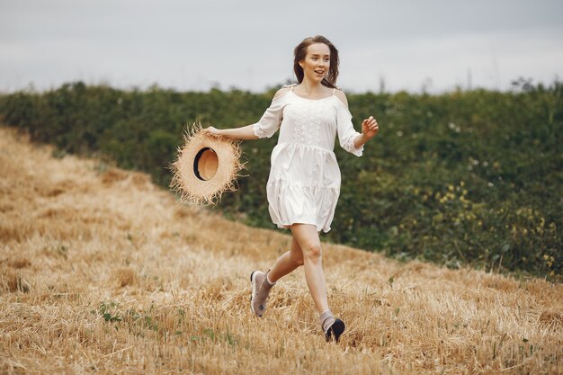 Mujer en un campo de verano. Dama con un vestido blanco.