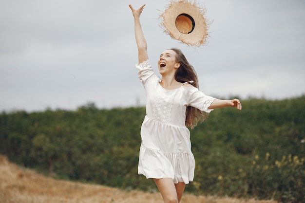 Mujer en un campo de verano. Dama con un vestido blanco.