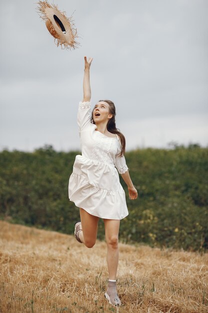 Mujer en un campo de verano. Dama con un vestido blanco.