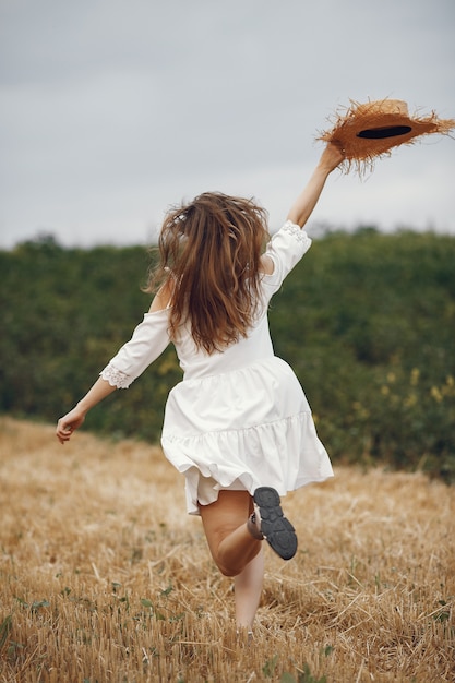 Mujer en un campo de verano. Dama con un vestido blanco.