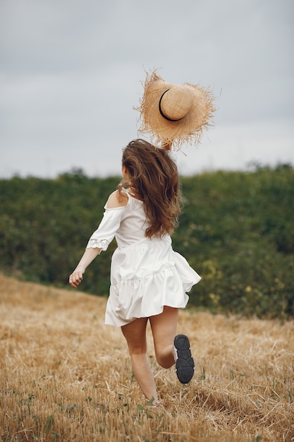 Mujer en un campo de verano. Dama con un vestido blanco.