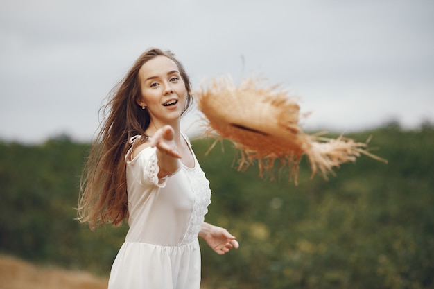 Mujer en un campo de verano. Dama con un vestido blanco.