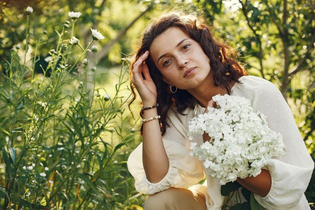 Mujer en un campo de verano. Morena con camisa blanca.