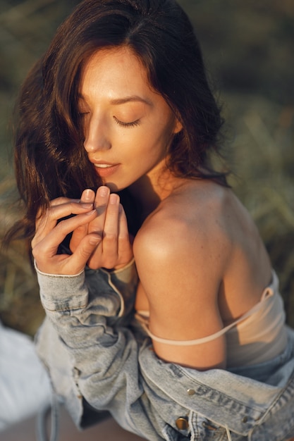 Mujer en un campo de verano. Morena en ropa interior marrón.