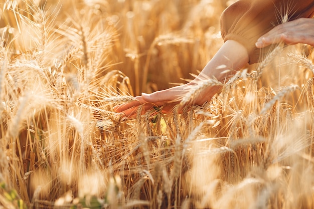 Mujer en un campo de verano. Morena con un suéter marrón.