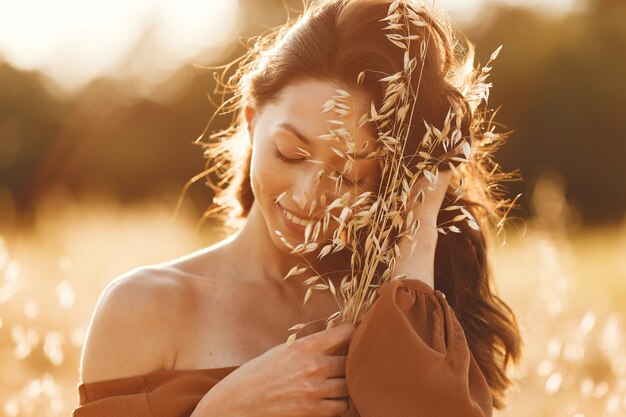 Mujer en un campo de verano. Morena con un suéter marrón.