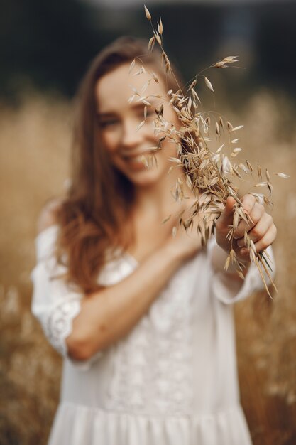 Foto gratuita mujer en un campo de verano. morena con un vestido blanco.