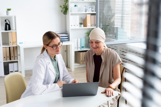 Foto gratuita mujer con cáncer de piel hablando con su médico