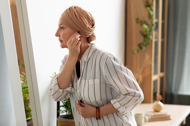 Mujer con cáncer de piel mirando en el espejo